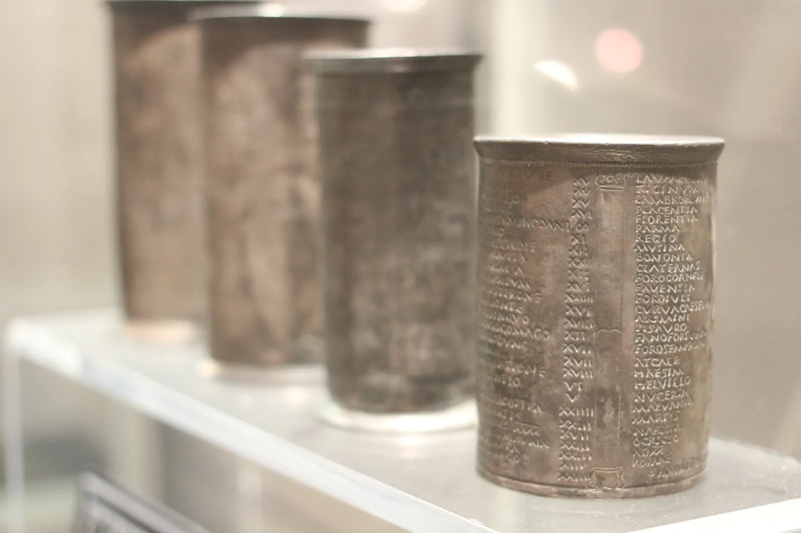 Los cuatro vasos de plata de Vicarello expuestos en una vitrina, con columnas de texto grabado