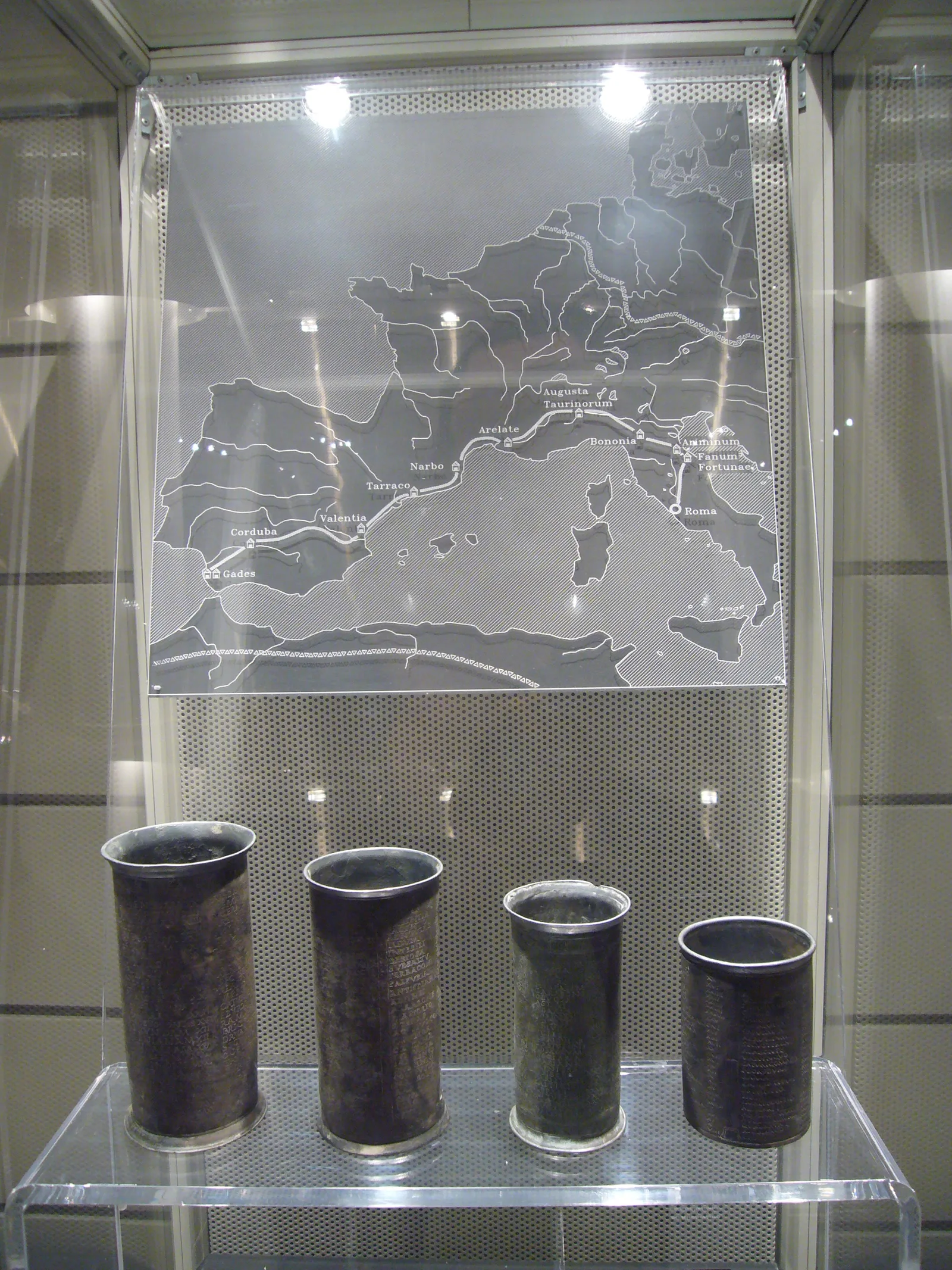 Los cuatro vasos de Vicarello expuestos bajo un mapa de su ruta en el Palazzo Massimo de Roma